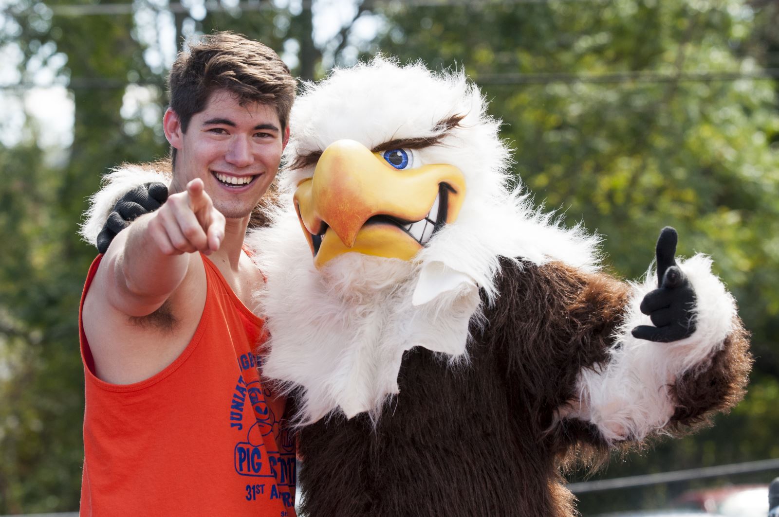 Student pointing at "You" with Alfie the Eagle, our mascot.